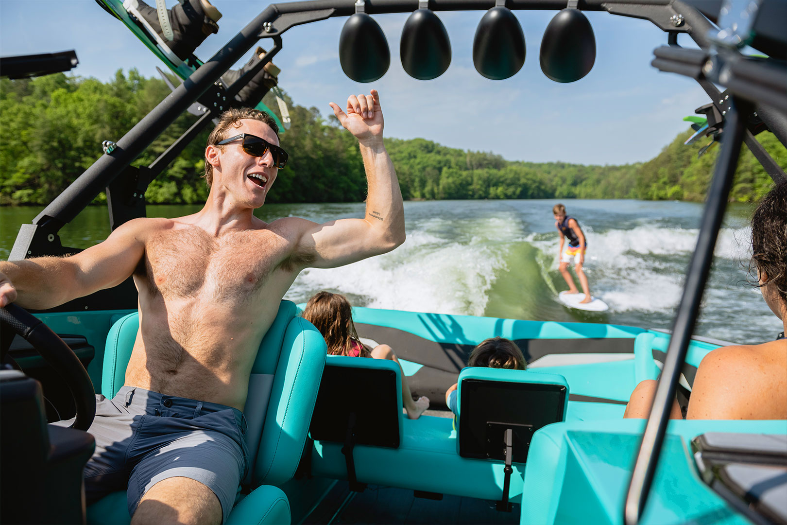 Driver Cheering on Wake Surfer Behind the Boat
