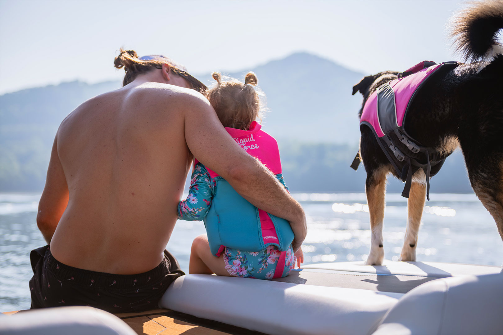 Father, Daughter, and Dog Sitting on Transom of Axis T250