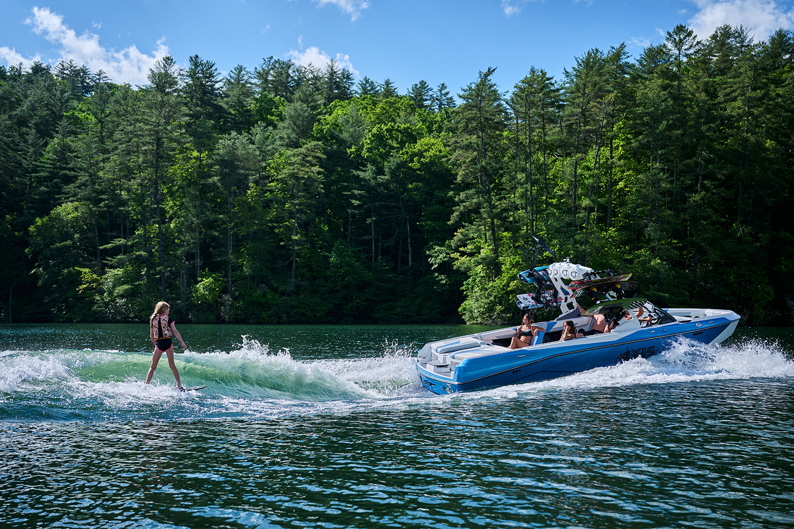 Wide shot of the Axis T250 with Collins Neal surfing behind it and the entire boat and wave in frame.