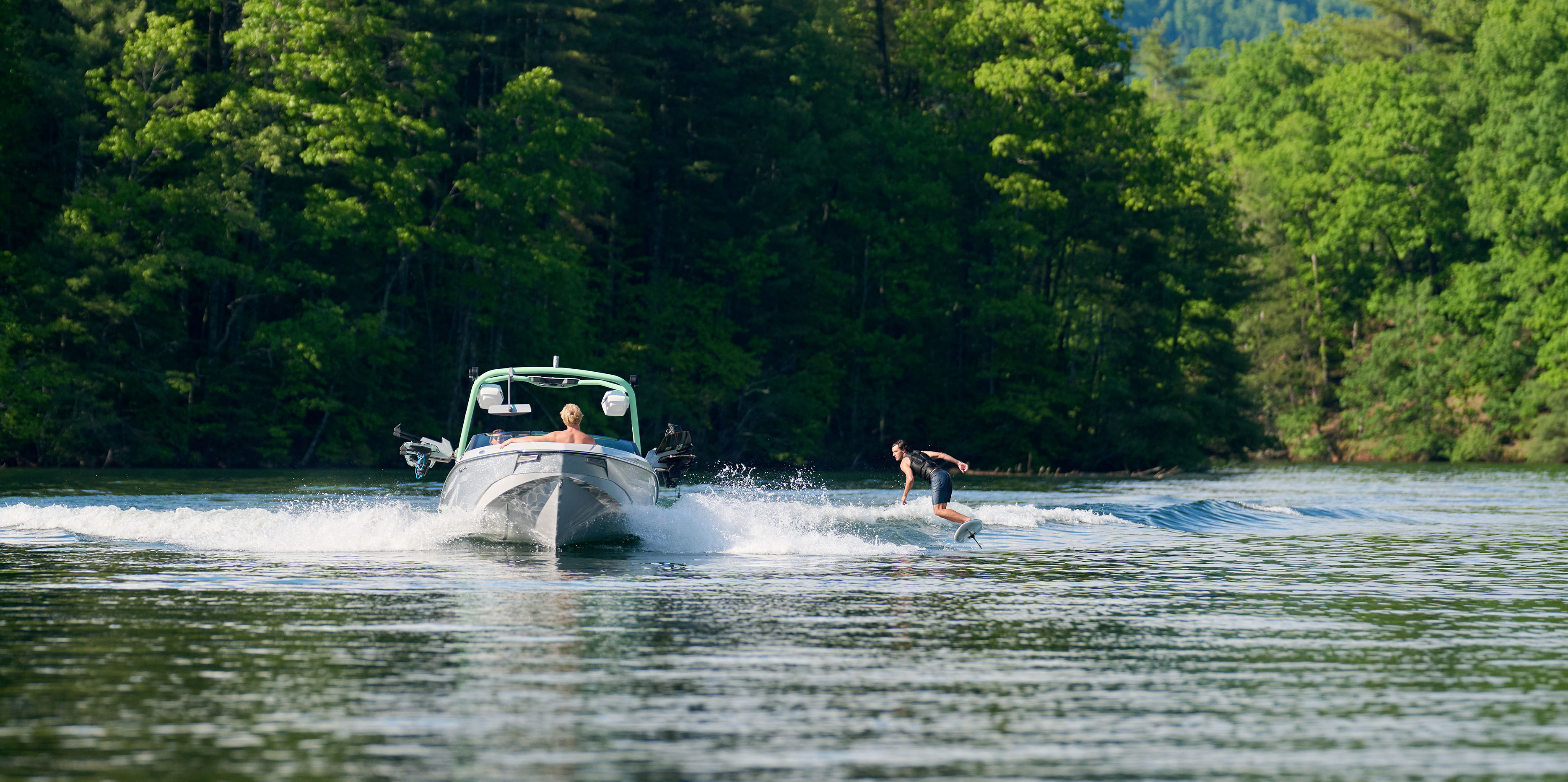Wakesurfer slashes through a clean wave behind the Malibu Wakesetter 22 LSV, showcasing responsive control and wave shape.